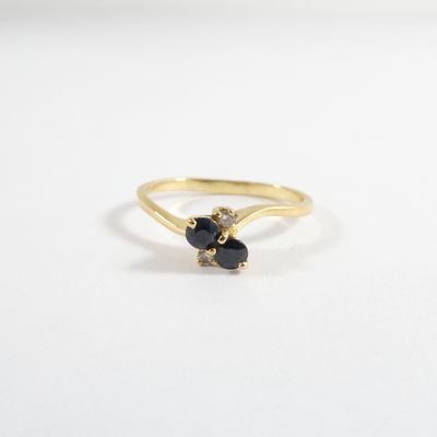 a close up of a gold ring with two black stones