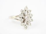 un gros plan d'une bague sertie de diamants en grappe sur fond blanc