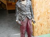 une statue représentant un garçon tenant une banane à la main