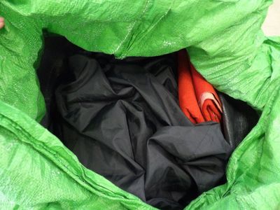 a green bag with a pair of orange shoes inside of it