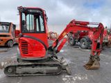 a red excavator that is parked in a parking lot