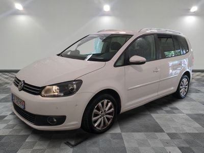 the white volkswagen touran is parked on a checkered tile floor