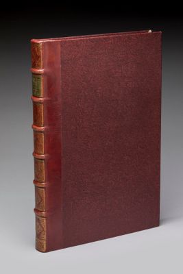 un vieux livre à la couverture rouge posé sur une table