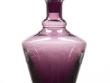 a purple glass vase with a spoon on it