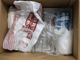 a cardboard box with a bunch of empty wine glasses inside of it
