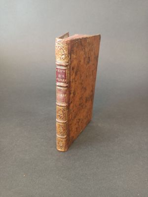 an old book sitting on top of a table next to a gray wall