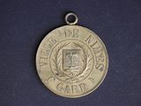 a silver medal on a blue surface with a black background