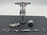 une présentation de bijoux en argent sur une table noire