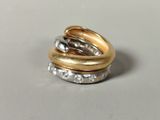 three gold and silver rings stacked on top of each other on a table
