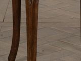 a wooden chair with a wicker seat on a tile floor