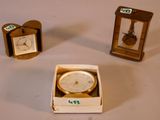 trois petites horloges posées dans une boîte sur une table