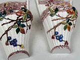 two vases that are decorated with flowers and leaves