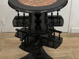 une photo d'une table noire avec un plateau en marbre posée sur un parquet