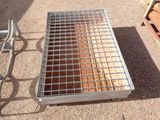 a metal grate on the ground next to a chair