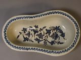 an old blue and white dish with a floral design on it