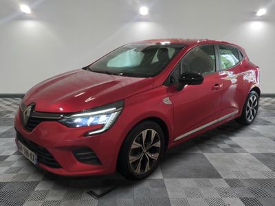 une voiture rouge est garée sur le sol en damier d'un garage