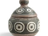 a black and white vase with a lid on a white surface