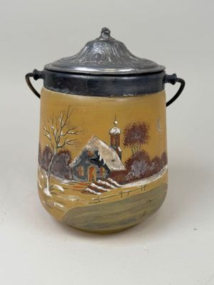 un petit pot avec une peinture dessus, posé sur une table