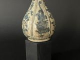 a blue and white vase sitting on a wooden stand
