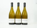 trois bouteilles de vin blanc posées les unes à côté des autres sur une table
