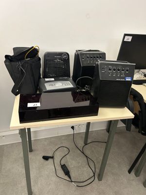 a table with a laptop, speakers, and other electronics on it