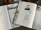 three books that are open on a table