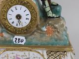 a figurine of a man and woman sitting on top of a clock