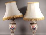 une paire de lampes posées sur une table, avec un abat-jour blanc et une bordure dorée