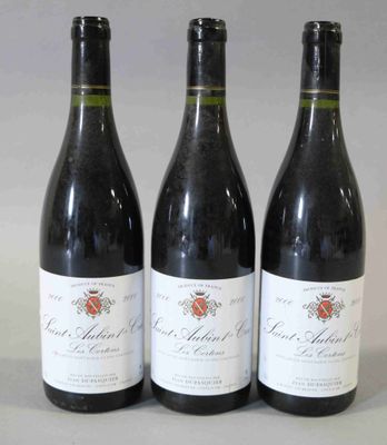 trois bouteilles de vin rouge sont alignées sur une table