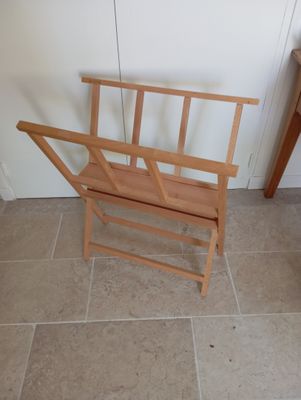 a wooden bench with a magazine rack on it