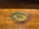 a brass plaque on the back of a wooden bench