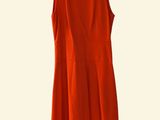 a red dress hanging on a hanger on a white wall