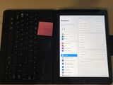 un ordinateur portable et une tablette posés sur un bureau sur lequel se trouve un post-it