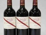 trois bouteilles de vin rouge posées côte à côte sur une table