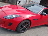 the red sports car is parked in front of a garage