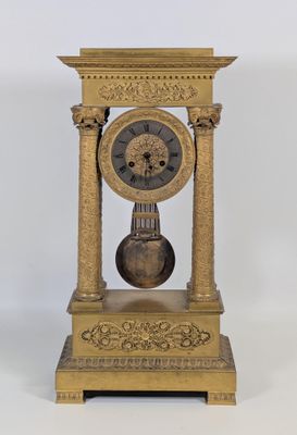 une horloge en or posée sur un socle en bois