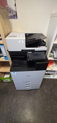 a printer sitting on top of a filing cabinet in a room