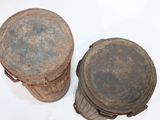 pair of old rusted metal buckets sitting on top of a white surface