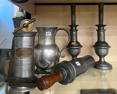 une étagère en verre sur laquelle sont posés des vases en argent et d'autres objets