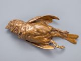 bronze bird on a gray surface