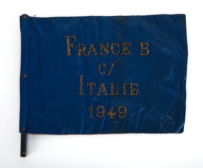 un vieux drapeau bleu avec une inscription dorée sur fond blanc