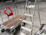 a dolly truck with a ladder and a vacuum on the floor