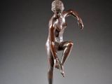 bronze statue of a woman in a pose on a pedestal