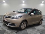 La voiture beige est garée sur le sol à damier du garage.