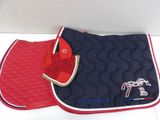 two saddle pads and a saddle pad are sitting on a table