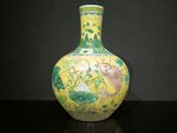 un vase jaune orné d'un motif vert et jaune