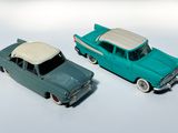 deux voitures jouets assises l'une à côté de l'autre sur une surface blanche