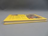 un livre jaune posé sur une table grise