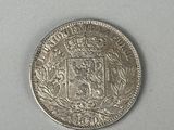 a close up of a silver coin on a white surface