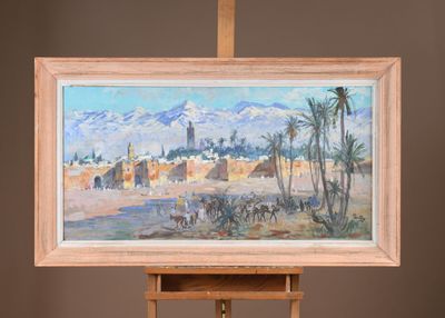 a painting on a easel with a painting of a village in the background